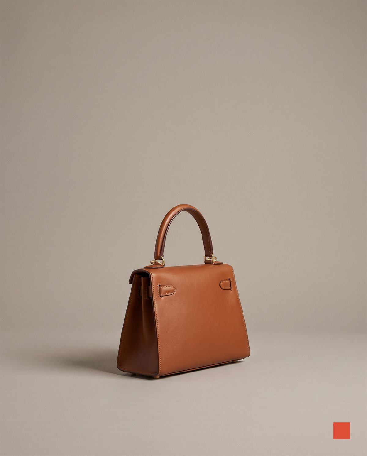 Finished frame: cognac leather handbag on a clean stone-grey backdrop